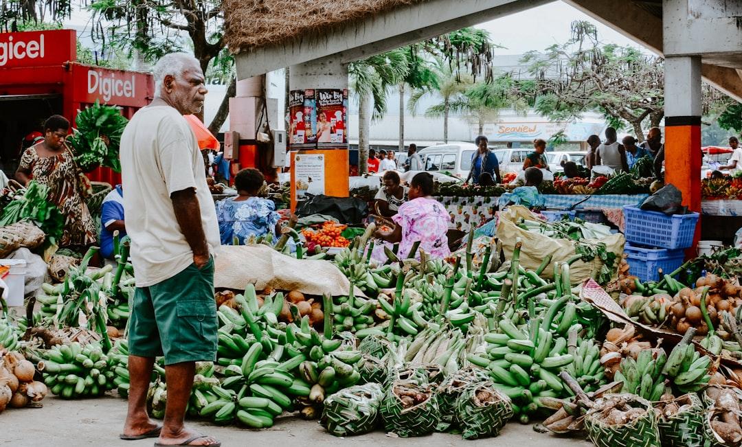 A man standing in front of the market in Port Vila, Vanuatu. I love seeing the fresh supplies - bananas, taro, coconuts. Lots of buying and selling. Definitely a good spot to interact with the friendly folks of the city. 