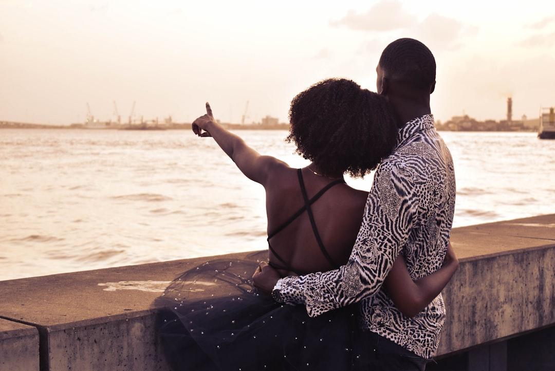 Young couple at riverside while girl is pointing towards the river