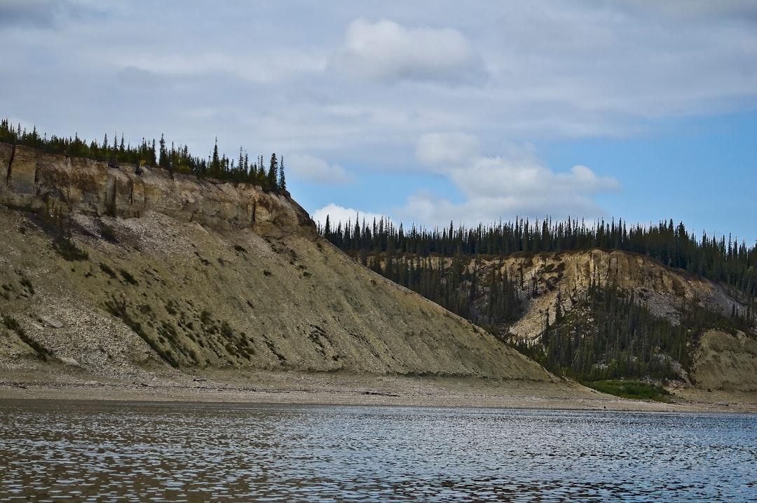 High river banks showing slump from permafrost with black spruce forest.