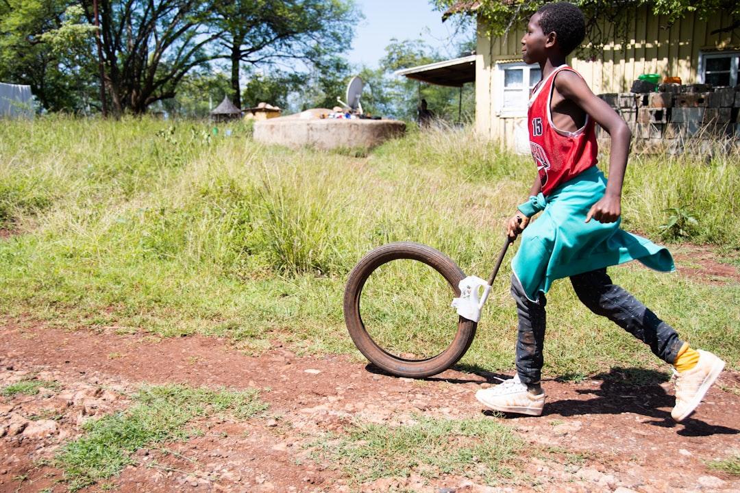 A boy runs with an old tire. This wheel trundling game has been a favorite of children all over the globe for centuries.