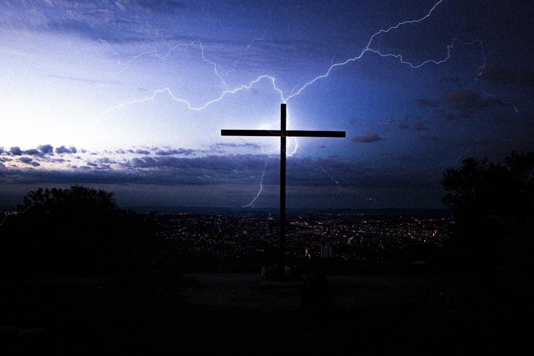 Lightning behind christian cross above Stuttgart during night